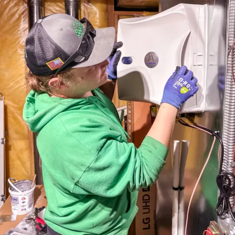 Technician installing an AprilAire air quality system