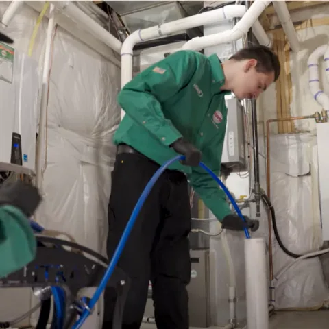 Cooper technician running a drain cleaning machine